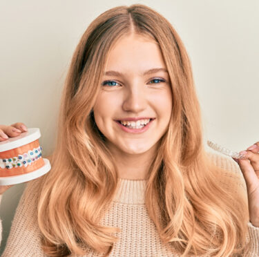 girl holding dental crown